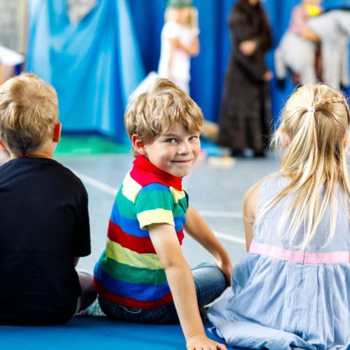 Kinder schauen dem Theaterspiel zu