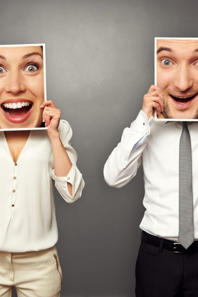 man and woman holding amazed happy faces. concept photo over grey background