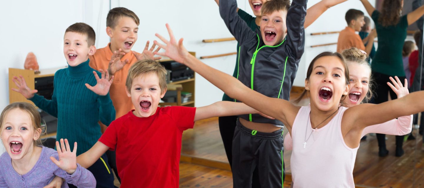 Kinder lachen und tanzen und haben Spaß